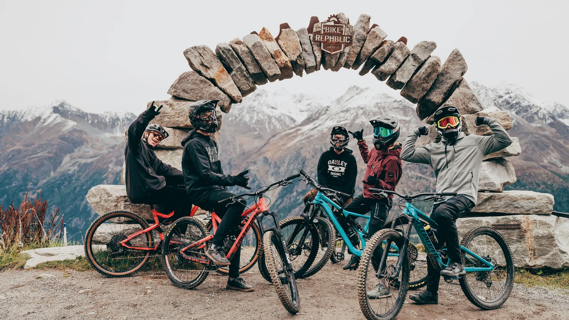 Gasthof Weisskugel: your walking holiday in the Austrian Alps Five mountain bikers beneath a stone arch with snow-capped mountains