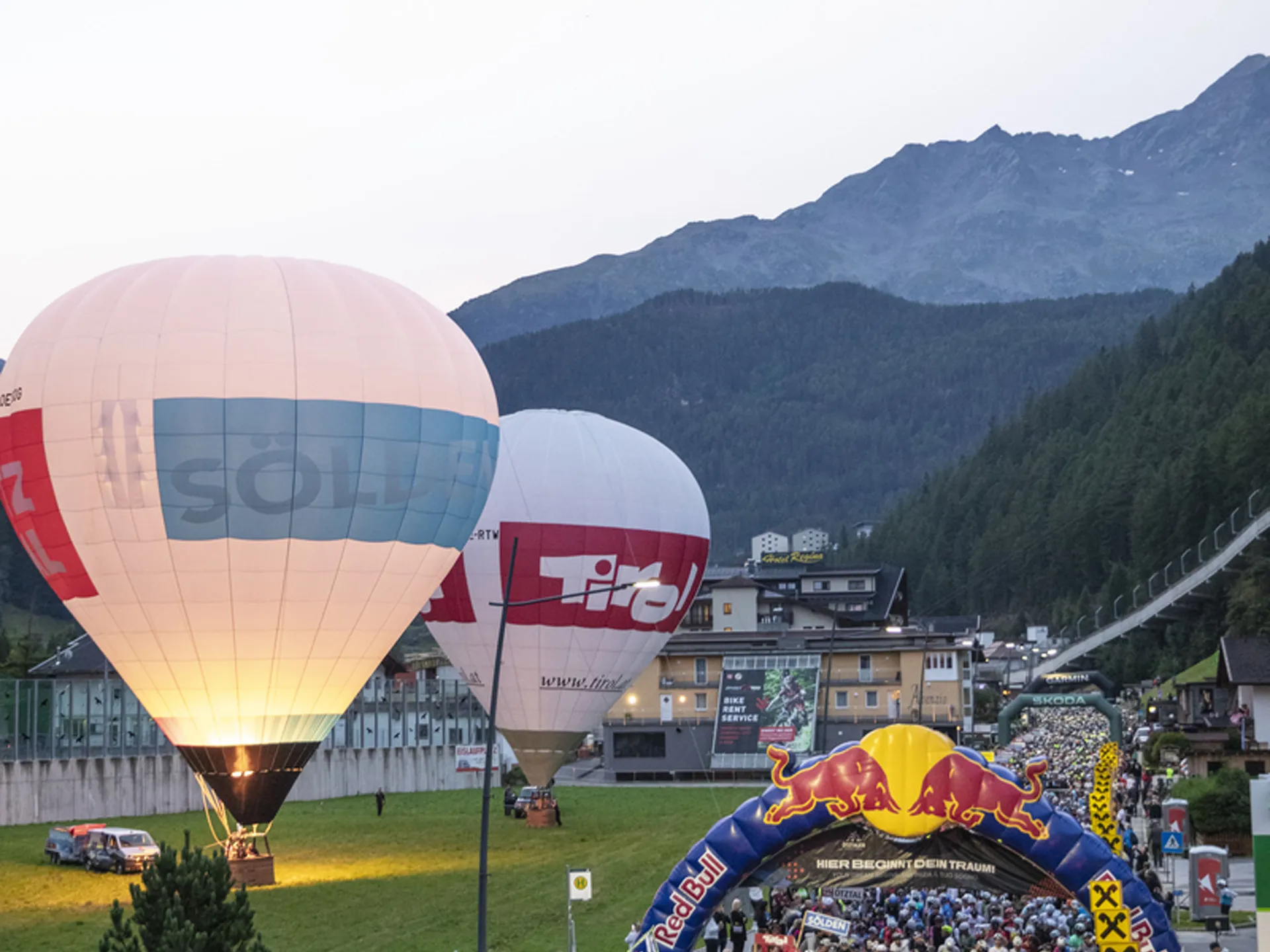 Gasthof Weisskugel: your walking holiday in the Austrian Alps Crowd beneath a Red Bull arch with hot-air balloons and mountain scenery