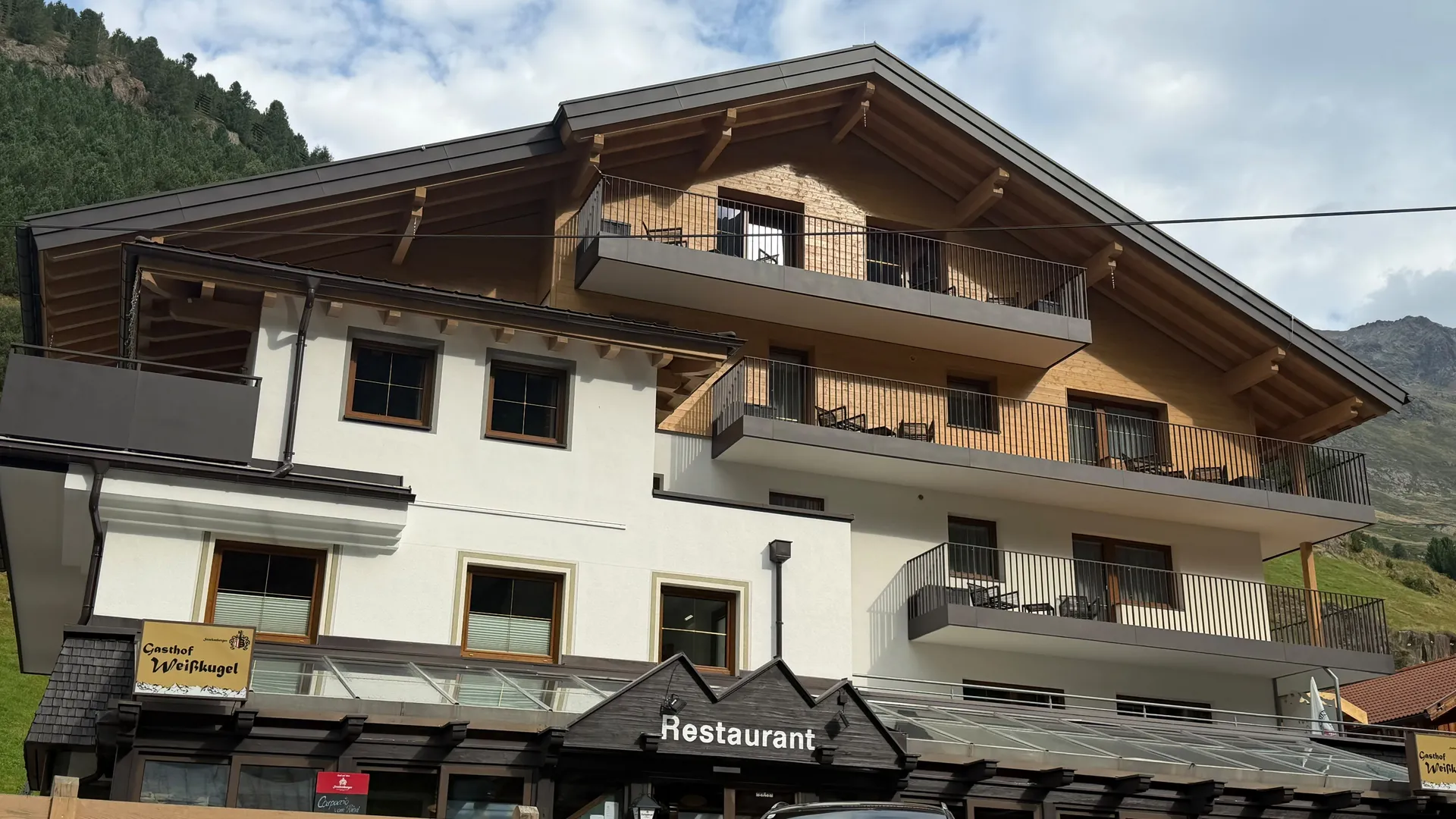 Weisskugel: dein Gasthof in Vent Gebäude mit Balkonen und Restaurant in einer Berglandschaft