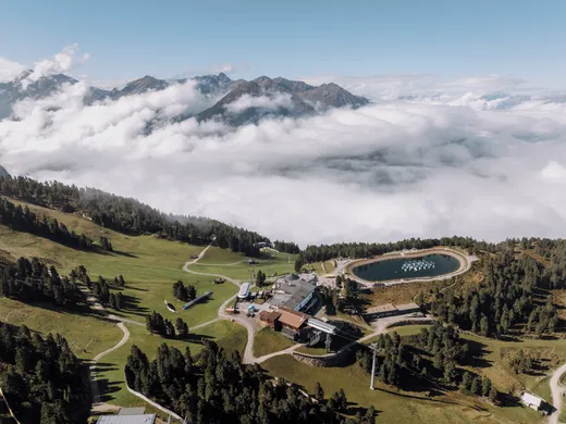 Gasthof Weisskugel: your walking holiday in the Austrian Alps Berglandschaft mit See, Gebäuden und Wolken unter blauem Himmel