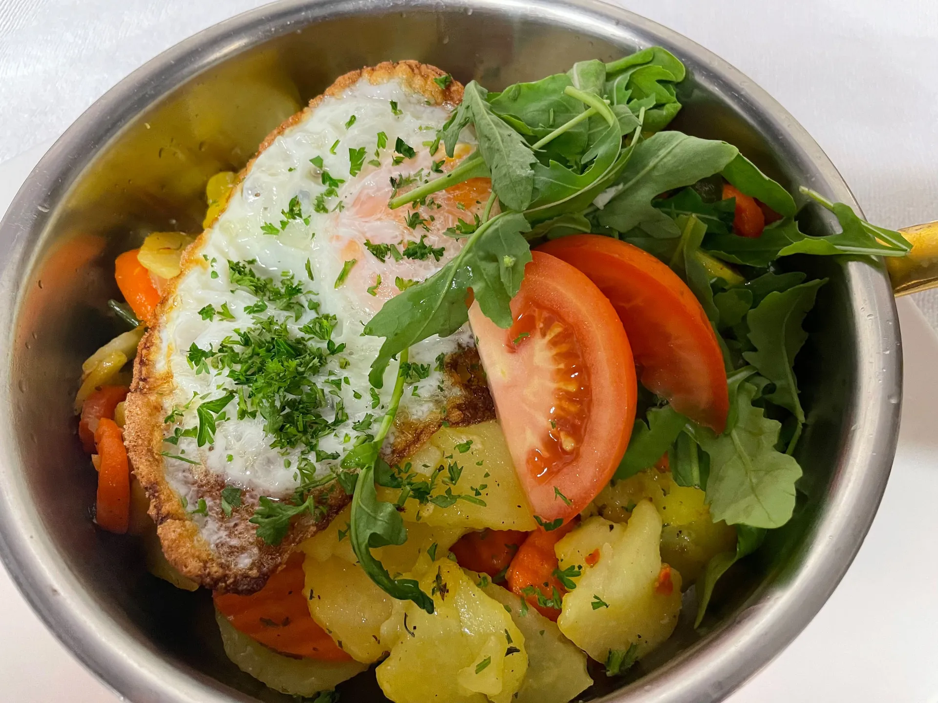 Weisskugel: dein Gasthof in Vent Schüssel mit Spiegelei, Kartoffeln, Karotten, Tomaten, Rucola und Petersilie