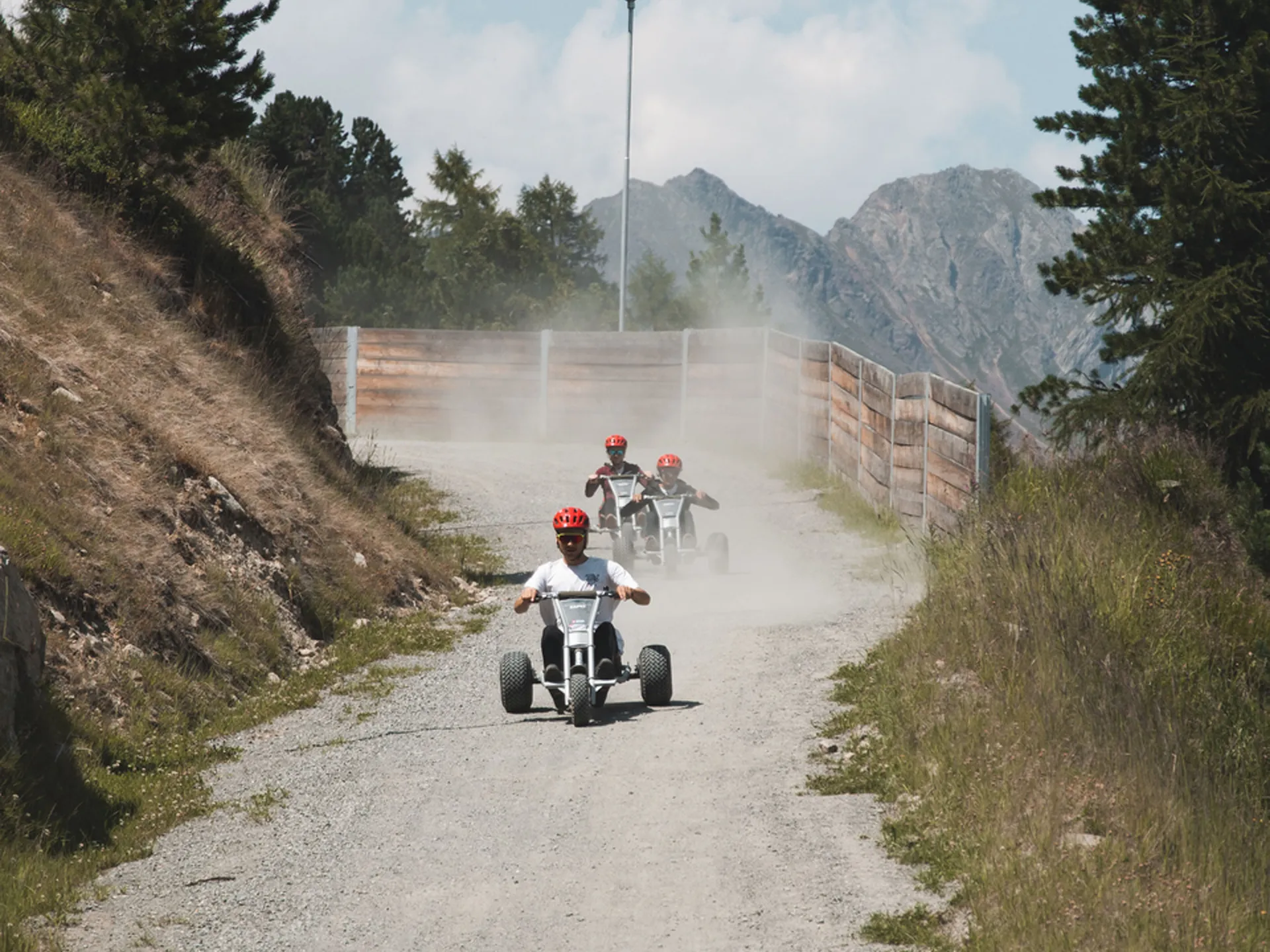 Gasthof Weisskugel: your walking holiday in the Austrian Alps Three people ride off-road karts along a dusty mountain path